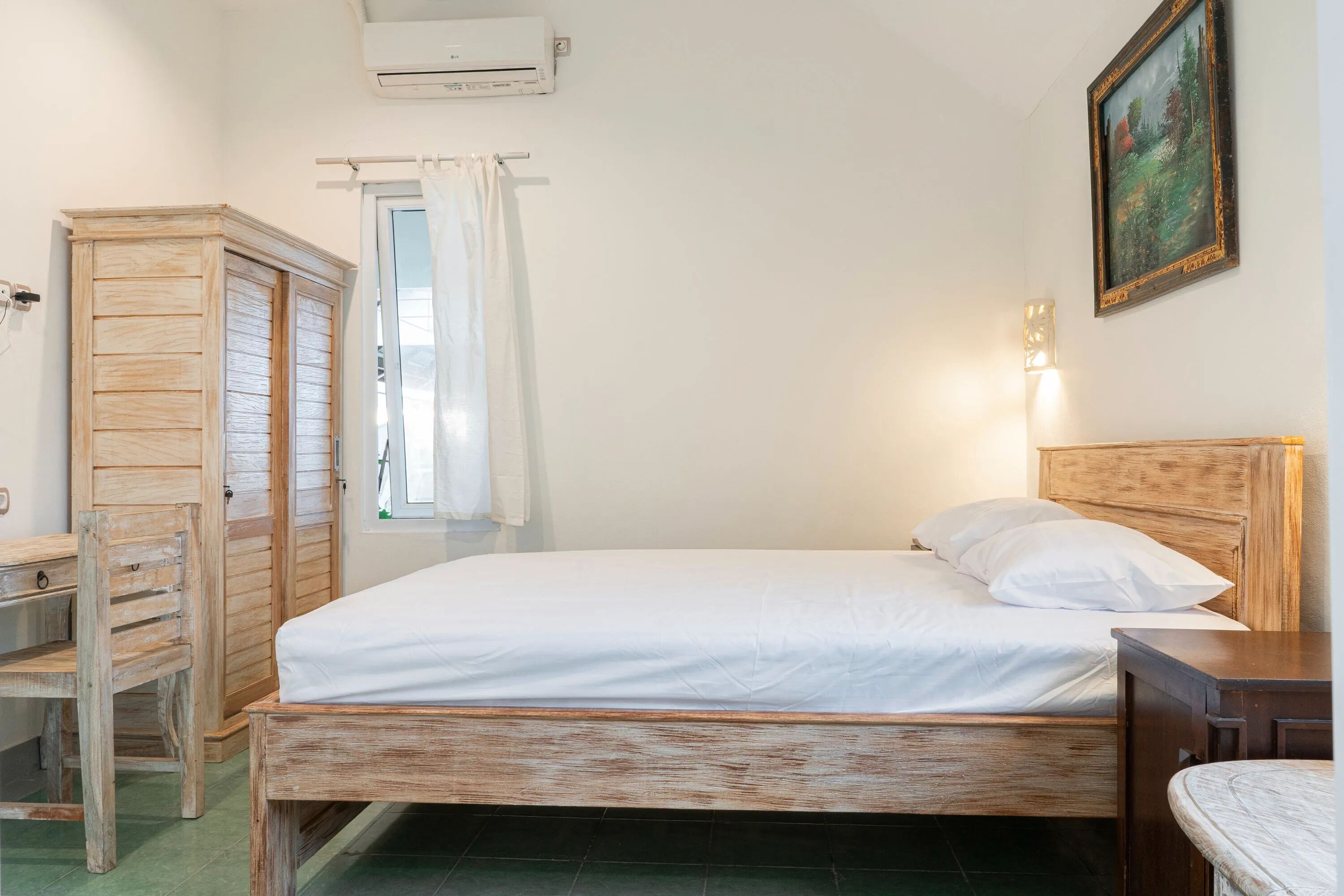 A bedroom with a wooden bed, a wooden wardrobe, a desk, and a chair.