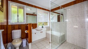 A bathroom with a toilet, sink, and glass-enclosed shower. - The Hillside Retreat, with amazing coastal and hinterland view. (Tamborine Mountain)