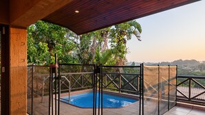 A covered swimming pool with a view of lush greenery and distant hills. - San Lameer Villa 10902 Private Pool  (Southbroom)