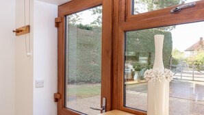 A wooden-framed window with a white vase on a wooden ledge. - The Milking Parlour (Cranbrook)