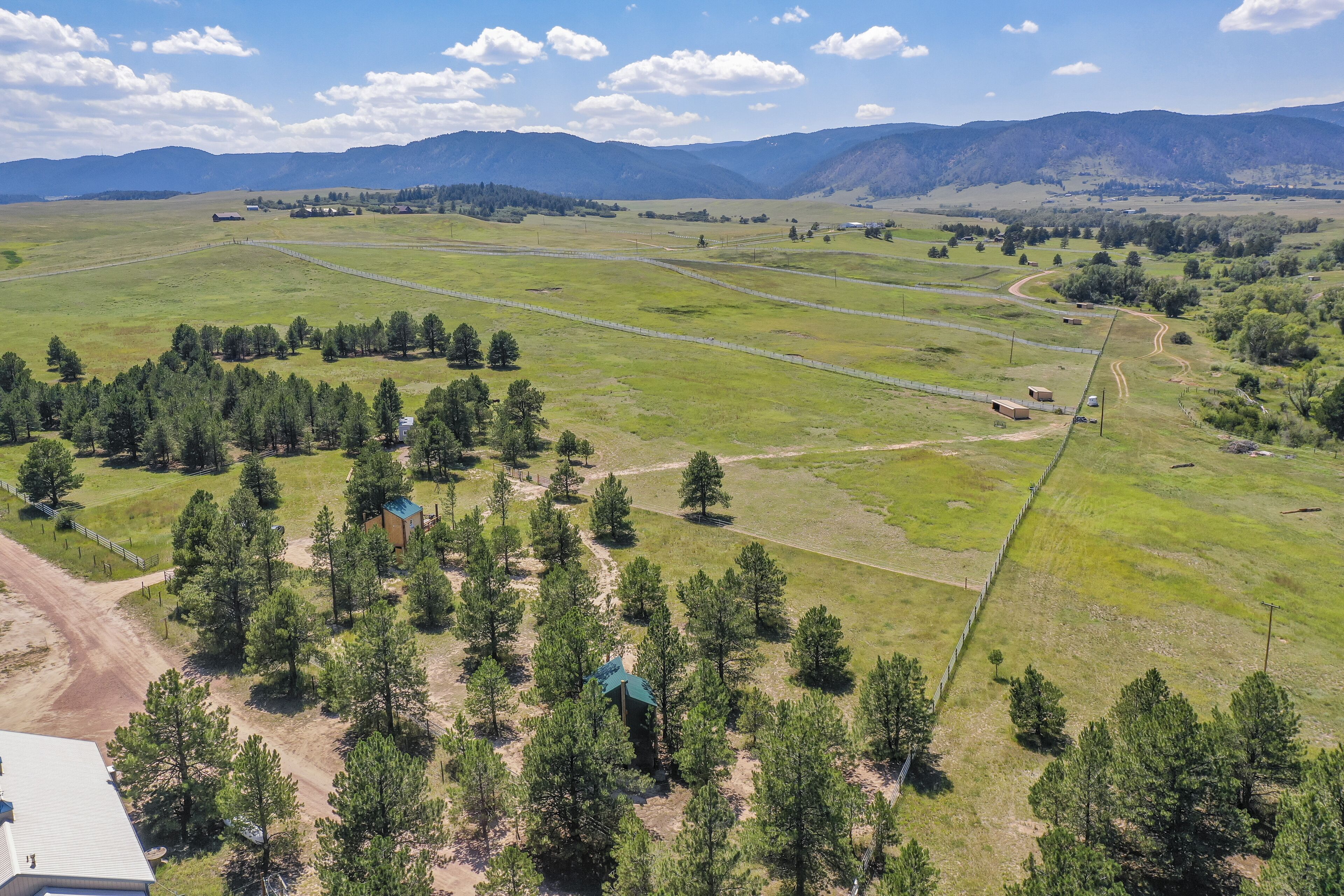 A rural landscape with fields, trees, and a few buildings.