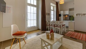 Un appartement moderne comprenant un coin repas, une cuisine et un espace de vie avec un canapé et une table basse.