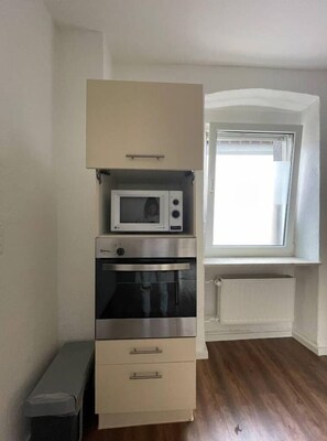 Efficient kitchen with microwave and oven, adjacent to a window.