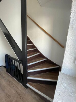 Stairs lead to an upper floor with a landing below.