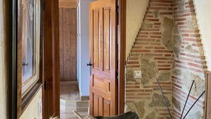 A wooden hallway with a stone wall and a wooden door leading to another room. - Casa Obis - Casa Rural con Jardín, Barbacoa y Unas Espectaculares Vistas (Muñeca)