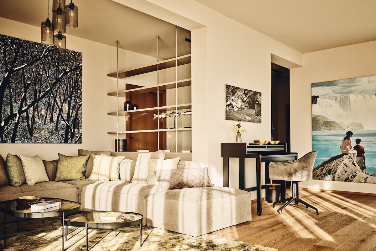 A modern living room with a sectional sofa, a coffee table, and a bookshelf.