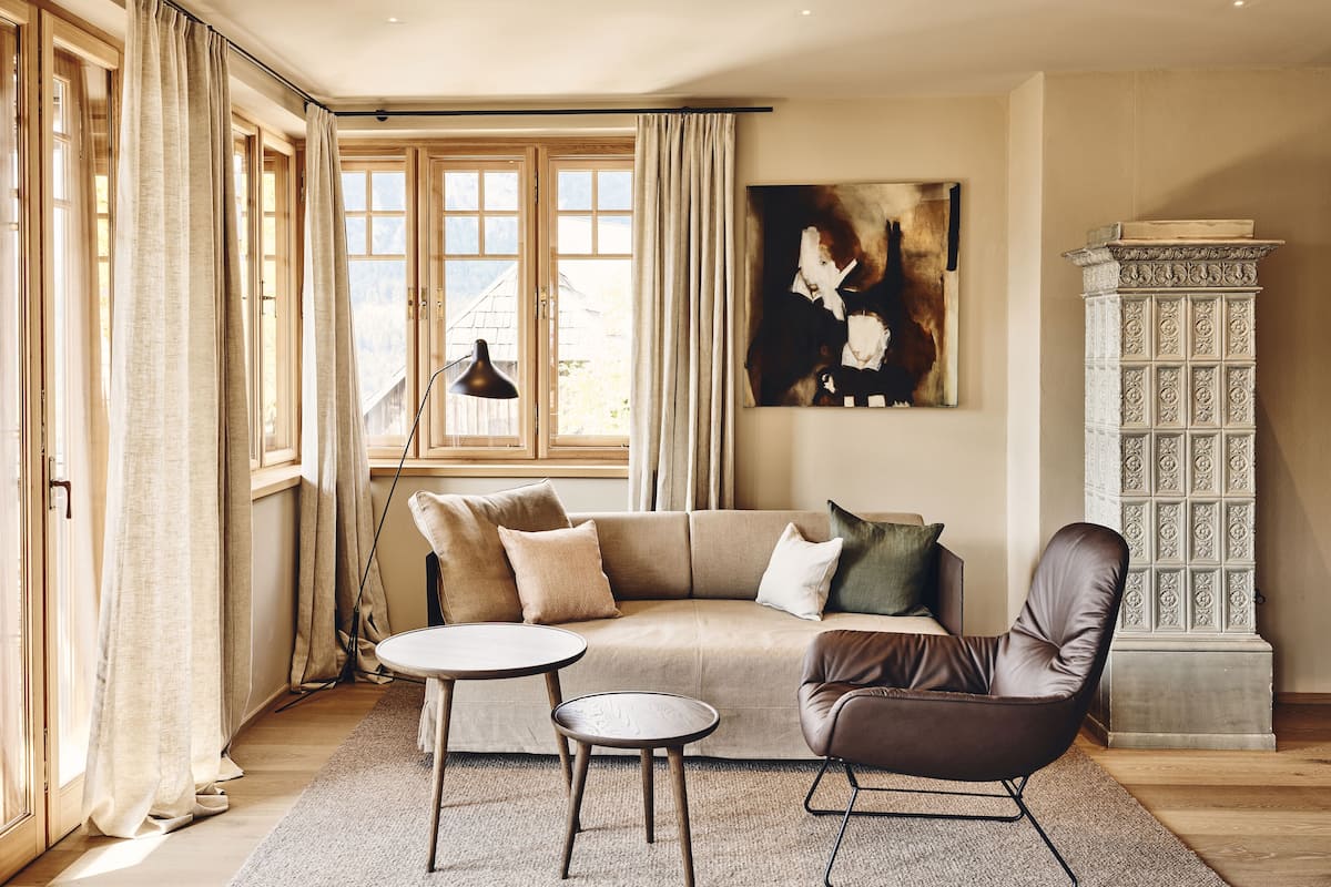 A living room with a sofa, two side tables, a chair, and a decorative cabinet.