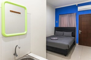 Relax in a stylish room with a large bed, modern sink, and convenient amenities.