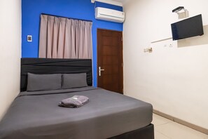 Cozy retreat with a single bed, air conditioning, and a flat-screen TV.