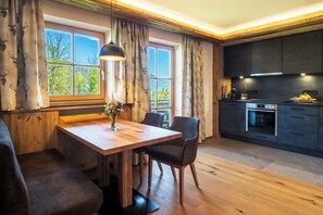Enjoy a warm and inviting space with a dining area near a window offering views of lush greenery.