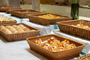 A buffet table with various food items in wicker baskets, including bread rolls and pastries with fruit toppings. - Guangzhou Baiyun Airport Rezen Select Hotel (Guangzhou)