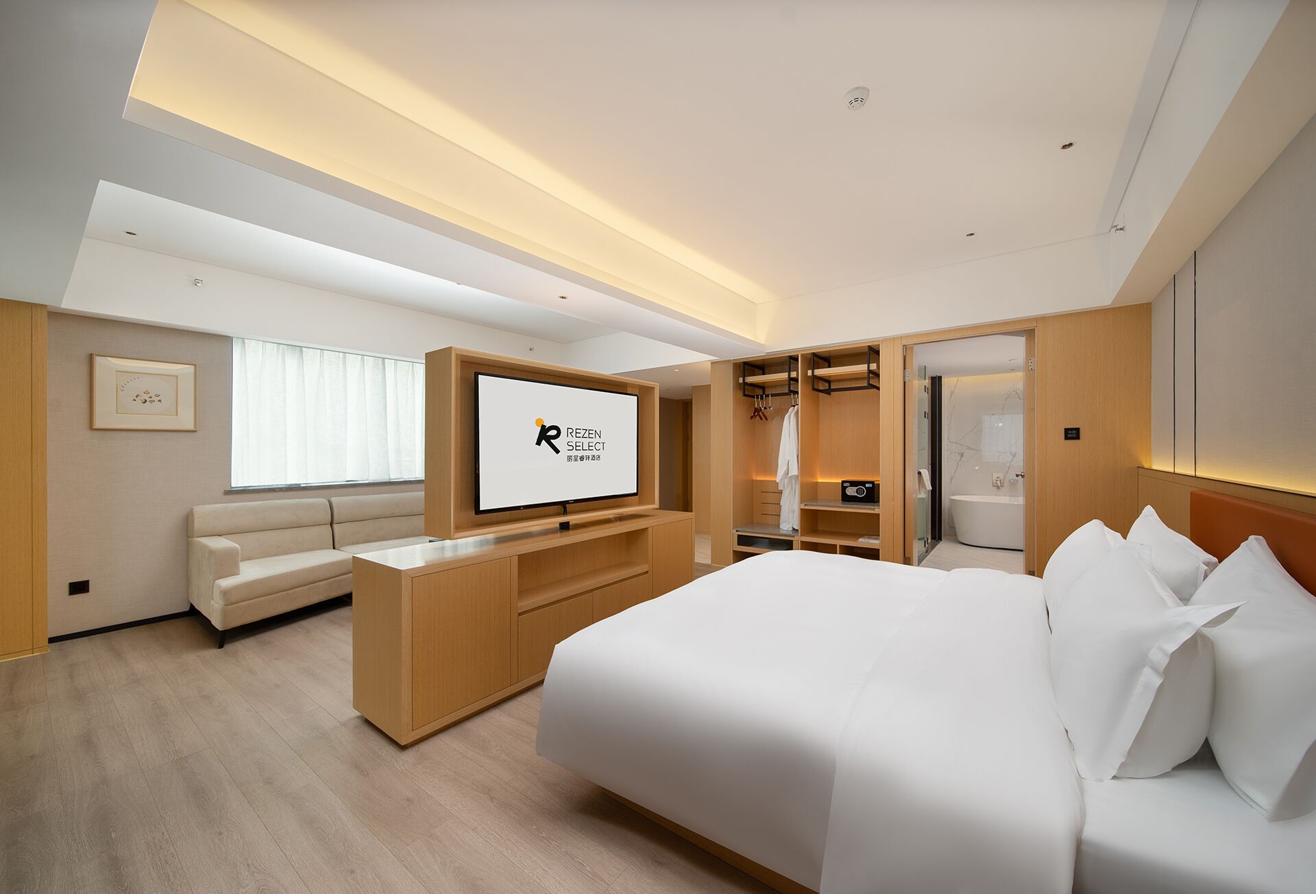 A modern hotel room with a large bed, a TV, a seating area, and a walk-in closet.