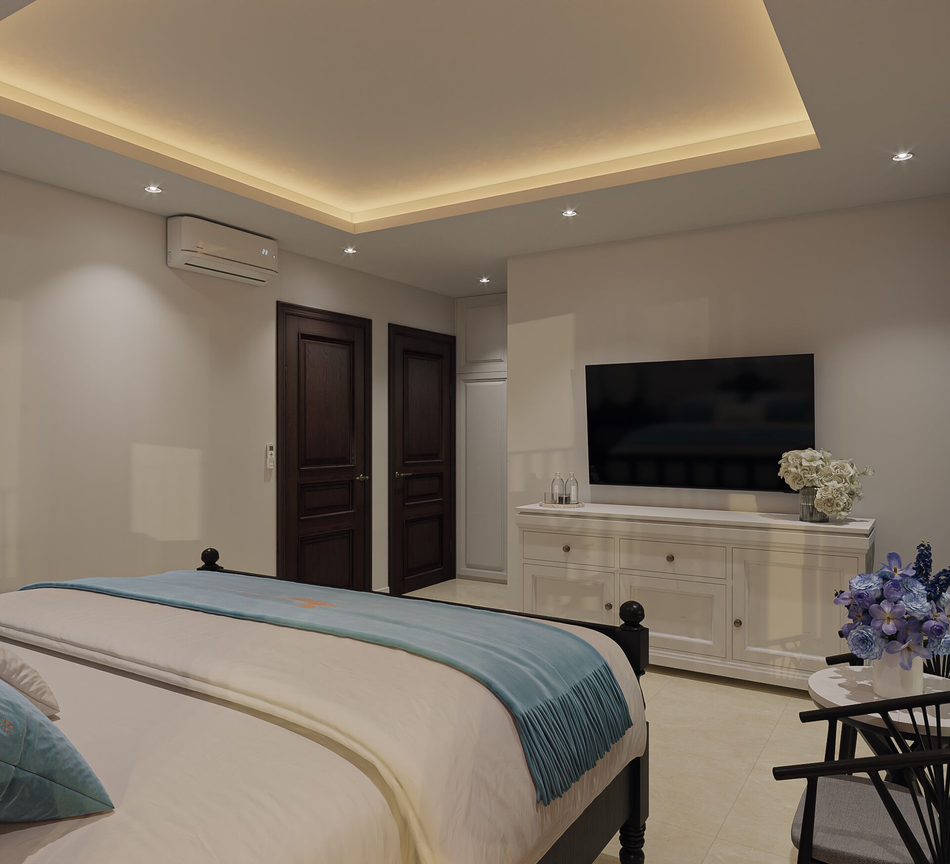 A bedroom with a bed, a TV, a dresser, and a small table with flowers.