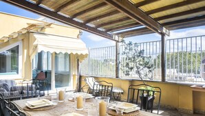 Un espace de restauration en plein air avec une table dressée pour quatre personnes, entourée de chaises.