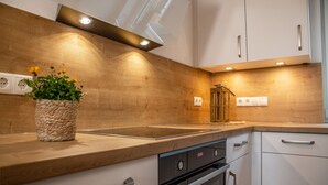 Eine moderne Küche mit Holzausziehtischen, einem Einbauofen und einer Spüle.