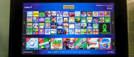 A tablet displaying a variety of mobile games with colorful icons and titles.