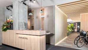 Un moderno mostrador de recepción con el nombre 'FUTUROTEL' y un patrón de suelo a cuadros.