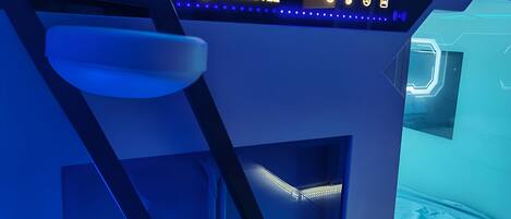 A futuristic room with a bed, a ladder, and a sign that reads "FUTUROTEL".