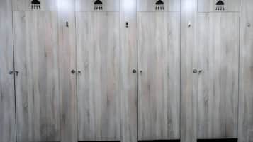Una fila de taquillas de madera con símbolos de ducha encima, indicando instalaciones para duchas.