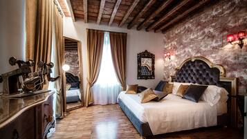 A bedroom with a large bed, wooden floor, and a mirror above the bed.