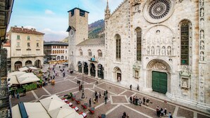A historic square with a prominent church featuring intricate facade carvings and a large circular window. - Aurum - Como Luxury Suites (Como)