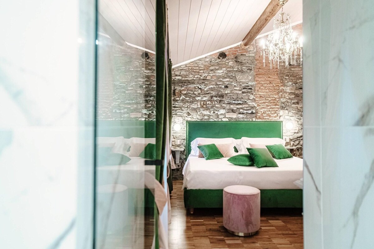 A room with a stone wall, a green bed, and a wooden floor.
