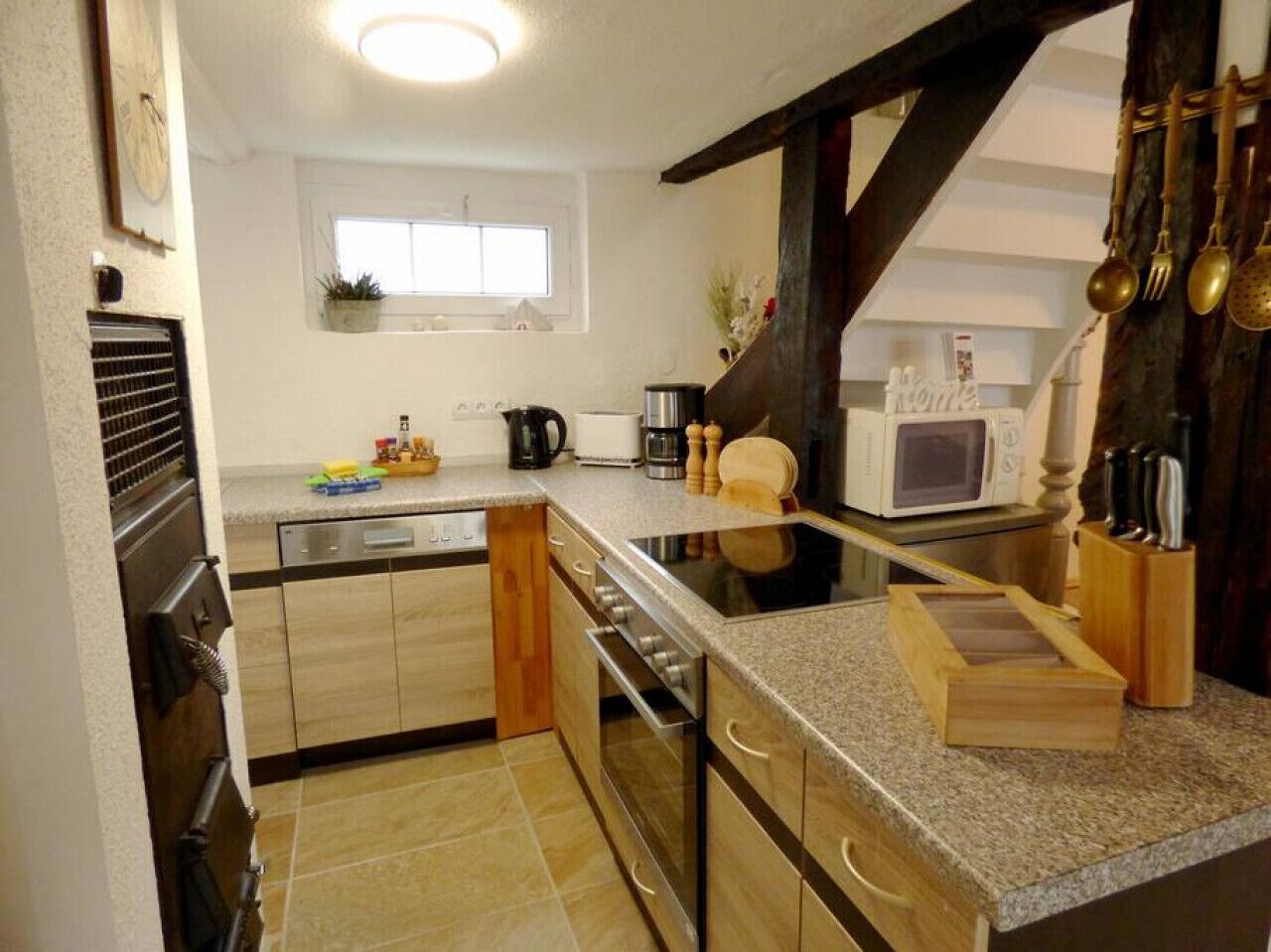 A kitchen with a central island, built-in oven, microwave, and a wooden cabinet.