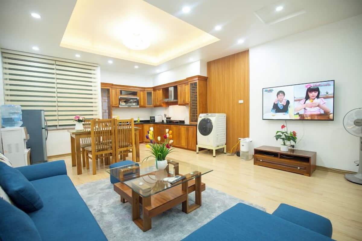 Una sala moderna con sofá, mesa de centro y televisor montado en la pared.