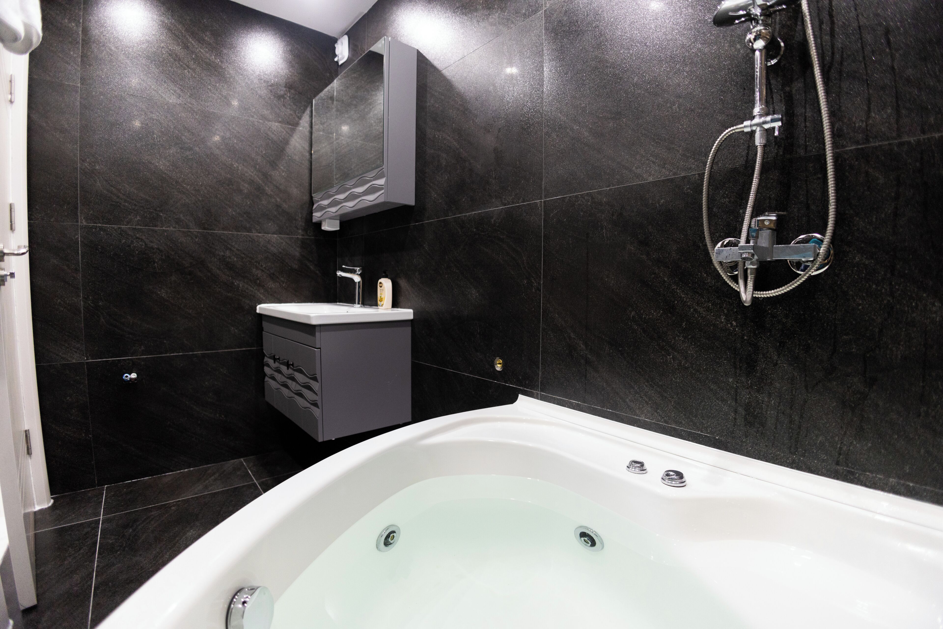 Un baño moderno con una bañera independiente, un tocador con espejo y un cabezal de ducha.