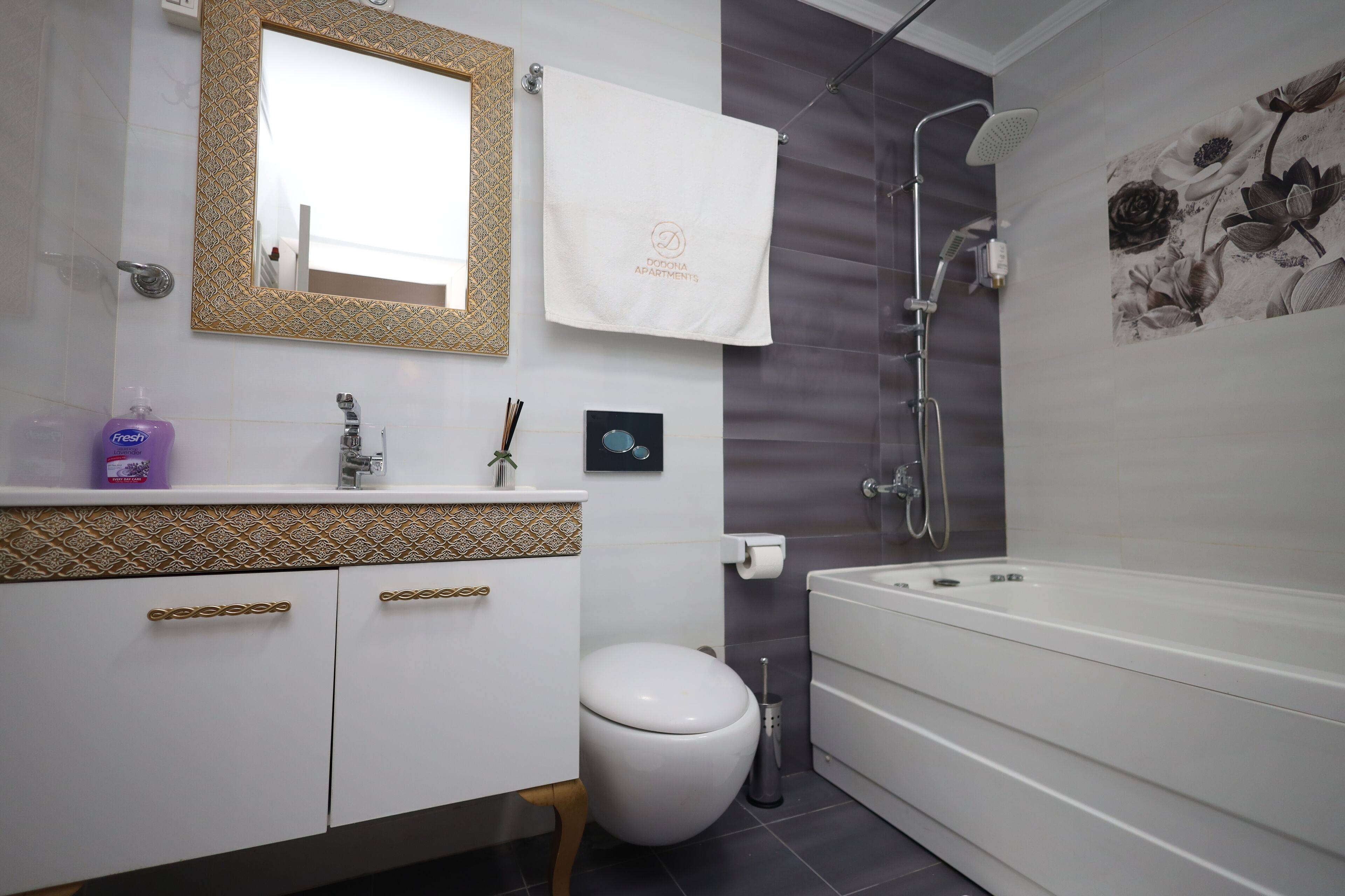A modern bathroom with a white sink, a toilet, a bathtub, and a shower.