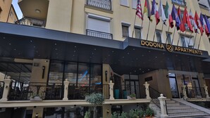 Exterior de Apartamentos Dodona con fachada moderna, varios balcones y una variedad de banderas.