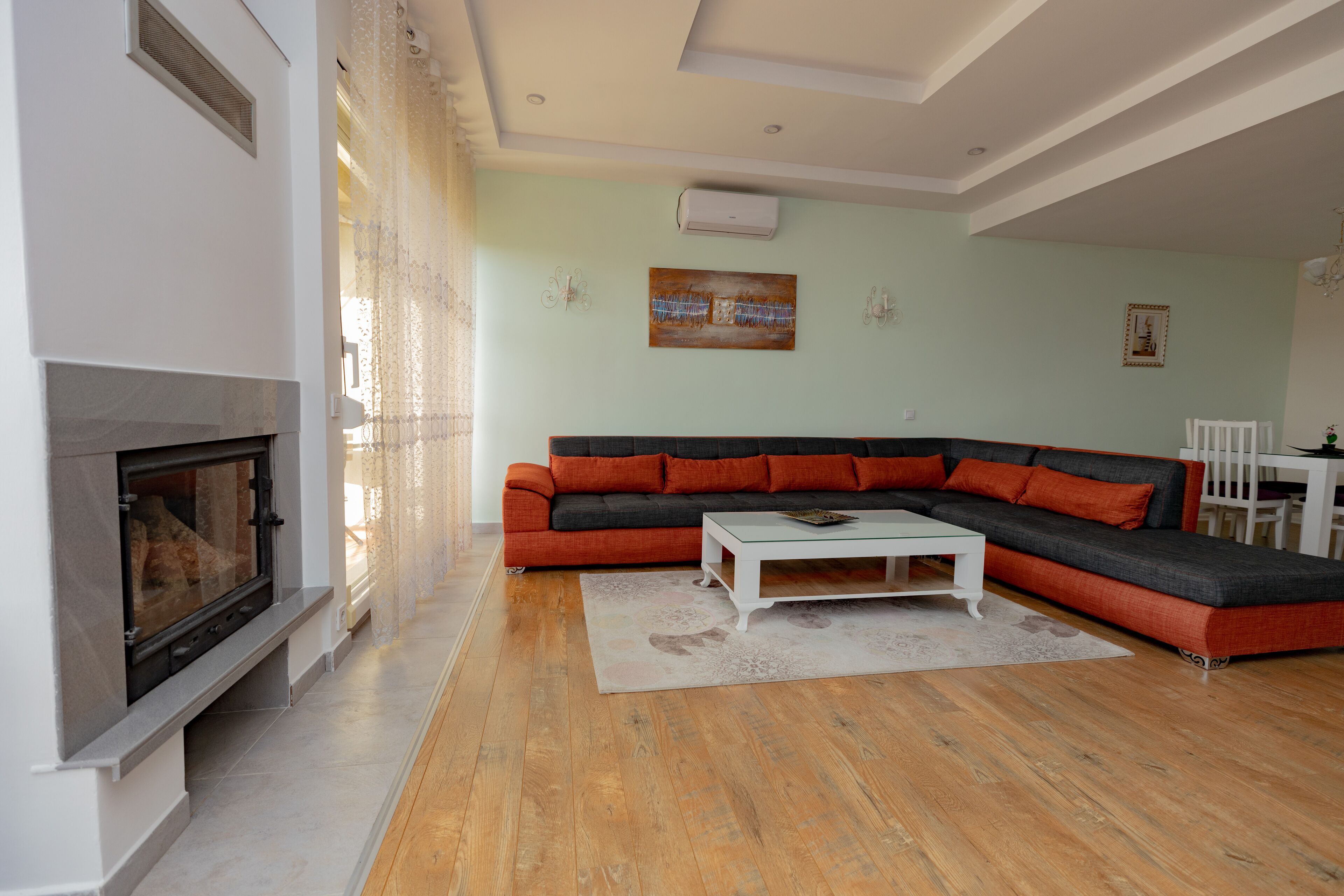 Una sala de estar con chimenea, un sofá modular y una mesa de centro.
