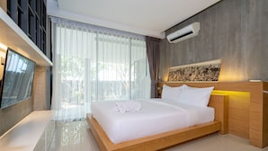 A modern hotel room with a large bed, a flat-screen TV, a bathtub, and a cityscape painting on the wall. - Designer Sea View Villa Natural Touch A1 (Kamala)