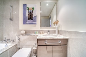 A modern bathroom with a large sink, a bathtub, and a shower.
