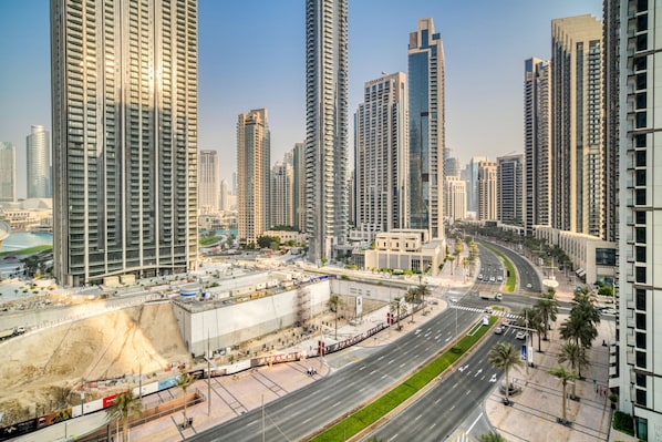 A high-rise urban area with modern architecture, a wide road, and a construction site.