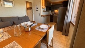 Een knus verblijf met een eethoek, kitchenette en een slaapbank.