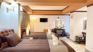 Une chambre d’hôtel avec deux lits, un bureau, une chaise, une télévision et un miroir.