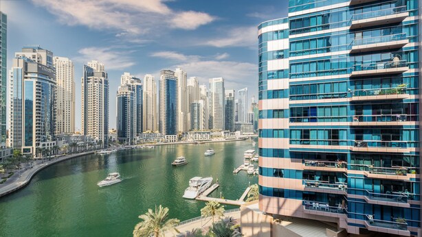 A high-rise building with multiple balconies overlooking a marina with boats. - Maison Privee - Sleek Apt with Dubai Marina Vws & Premium Facilities. (Dubai)