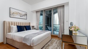A modern bedroom with a large bed, a glass desk, and a balcony with city views. - Maison Privee - Sleek Apt with Dubai Marina Vws & Premium Facilities. (Dubai)