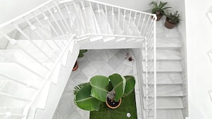 A white spiral staircase with a small green area at the bottom.