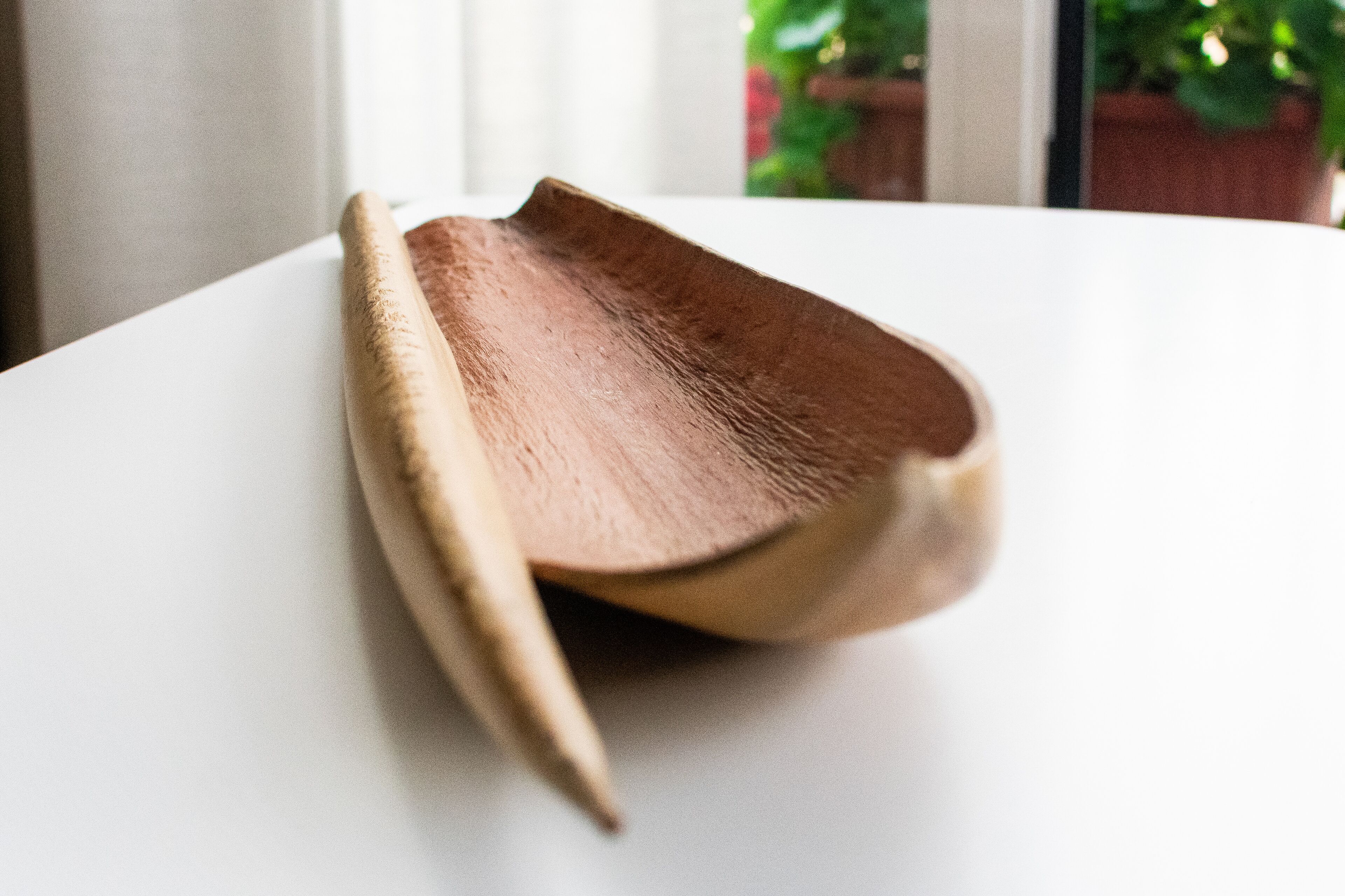 A wooden object on a white surface.