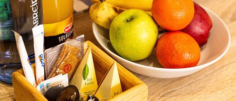A wooden tray with tea bags and a bottle of orange juice.