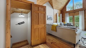 Arredamento in legno con un divano, un cartello che indica una sala giochi e una grande finestra.