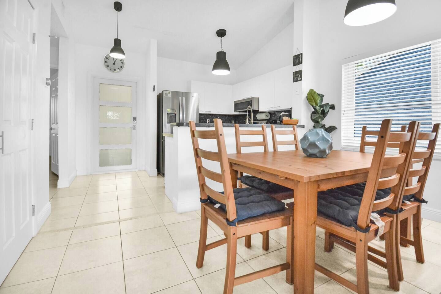 A modern kitchen with white cabinets, a built-in oven, and a refrigerator.