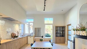 Una cocina moderna con zona de comedor, ventanas amplias y horno empotrado.