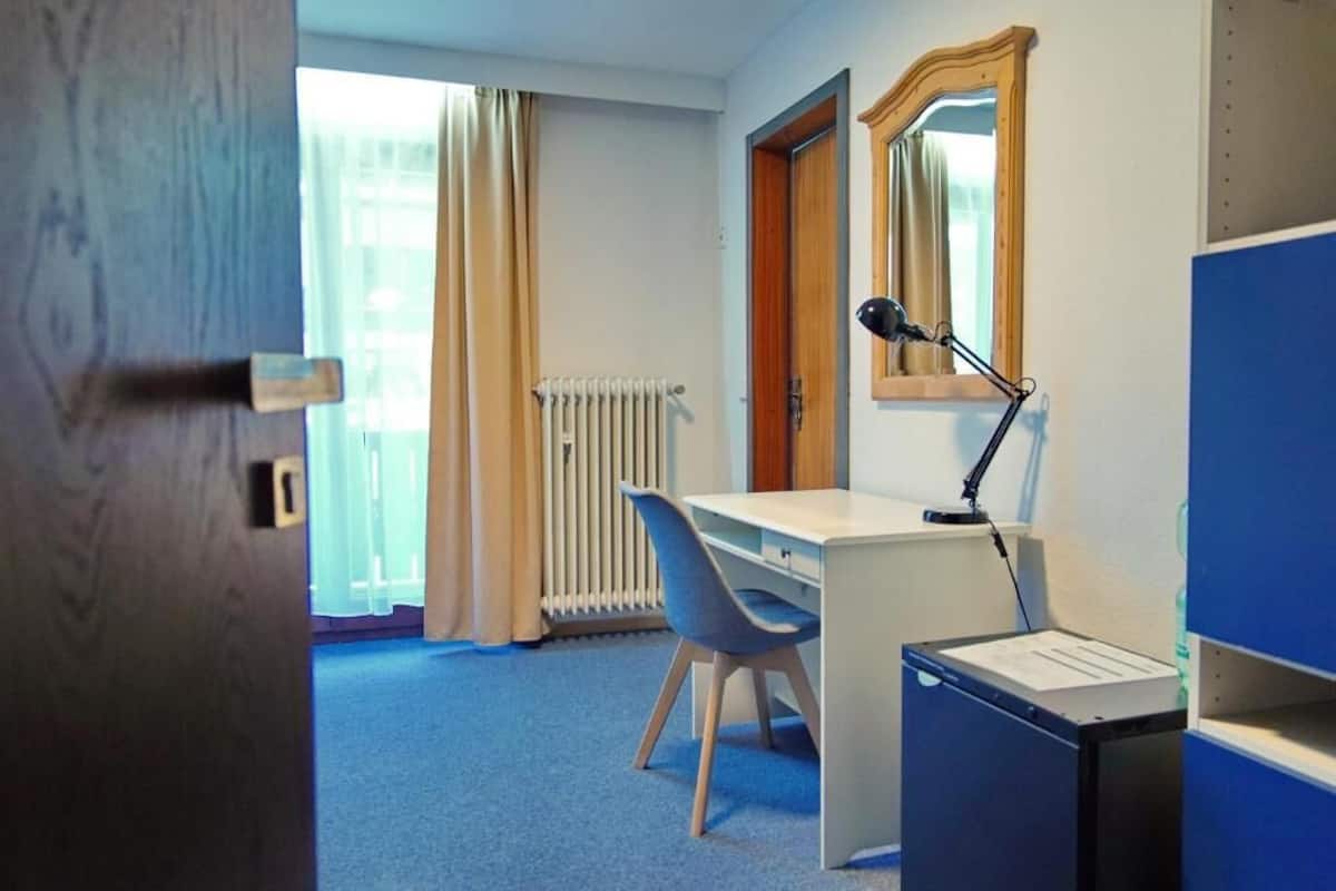 Eenpersoonskamer | Een bureau, een laptopwerkplek, beddengoed