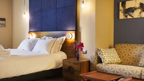 A hotel room with a bed, bedside table, nightstand, and a sofa. - TLV Port Boutique Residence (Tel Aviv)