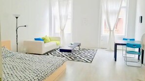 Moderni hotellihuone, jossa on sänky, työpöytä ja tuoli.