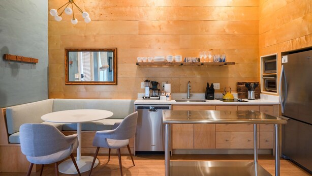 A modern kitchen with a built-in dishwasher, stainless steel appliances, and a wooden accent wall.