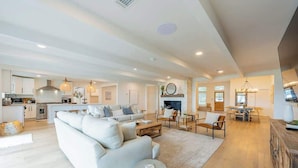 A spacious living area with a sofa, coffee table, and dining table. - "Waterfront Paradise" Dock, Pool, Boathouse (JACKSONVILLE)